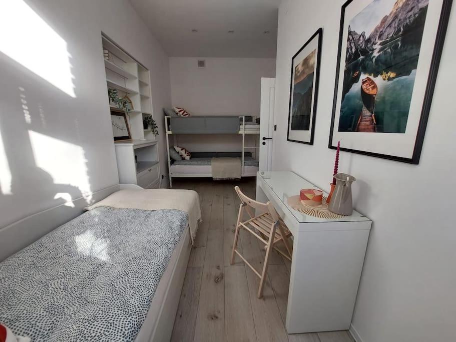 um pequeno quarto com uma cama e uma secretária em Przytulne mieszkanie w kamienicy em Radomsko