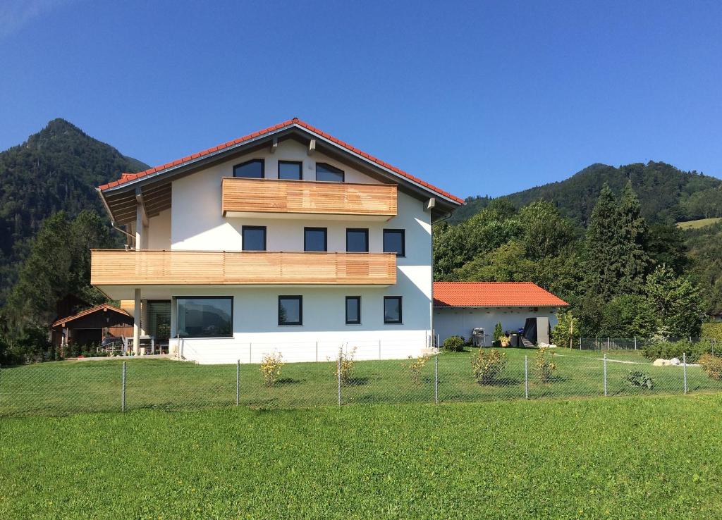 ein Haus auf einem Hügel mit einem grünen Feld in der Unterkunft 5-Sterne Active Ferienwohnung Chiemgau in Marquartstein