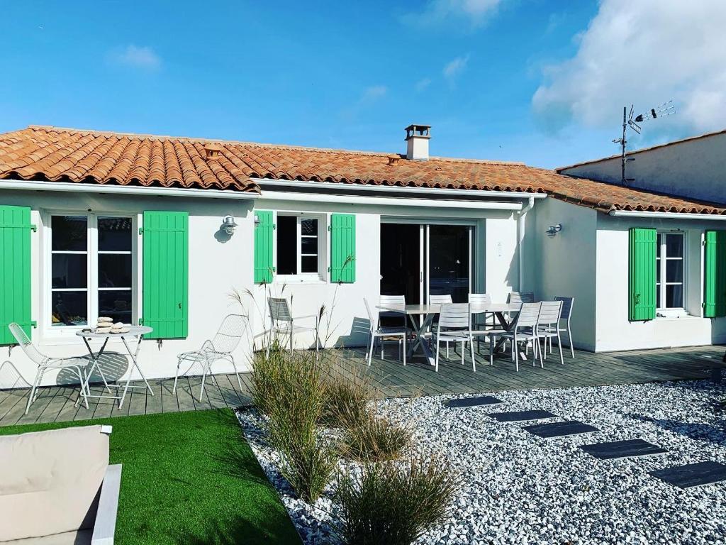 Cette maison blanche dispose de volets verts et d'une terrasse. dans l'établissement Maison 10/12 pers à 5 min du Phare des Baleines, à Saint-Clément-des-Baleines