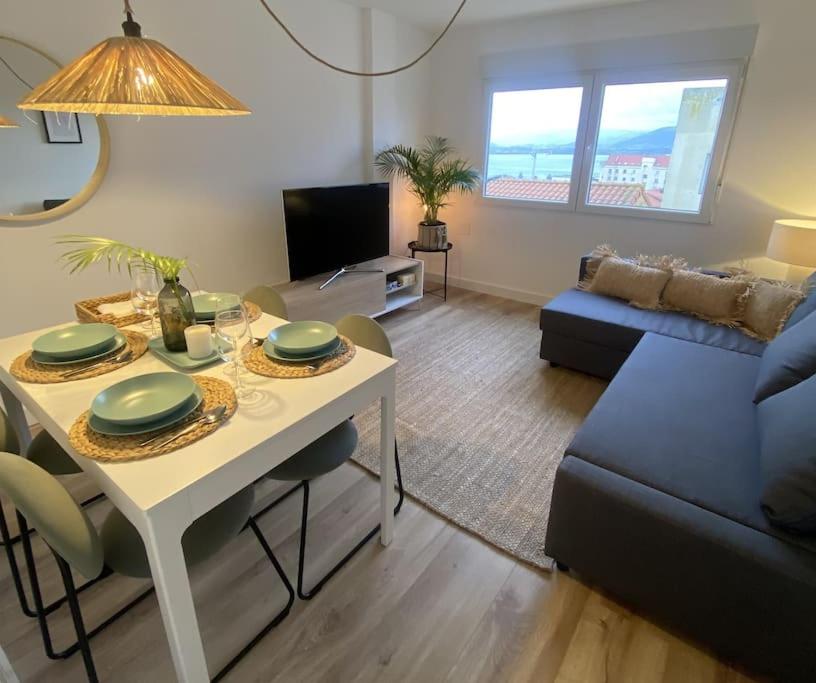 sala de estar con mesa y sofá en Apartamento en Santander con vistas al mar, en Santander