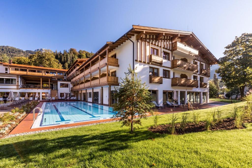 una vista exterior de un hotel con piscina en Das Bayrischzell Familotel Oberbayern, en Bayrischzell