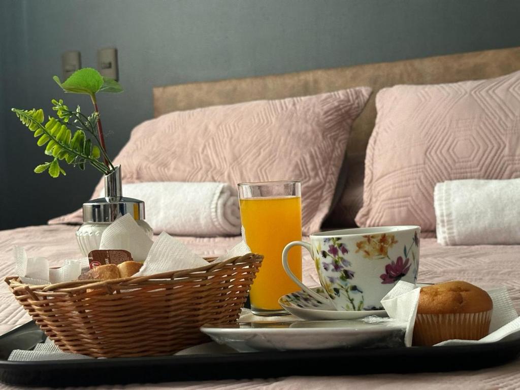 a tray with breakfast foods and drinks on a bed at Hotel Vitali in Concepción