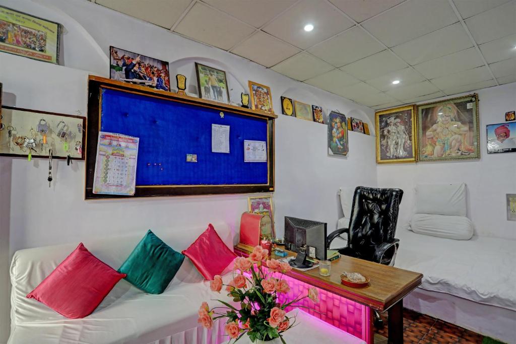 Habitación con sofá con almohadas coloridas y escritorio. en Super OYO Hotel Ram Ji Vatika, en Datia