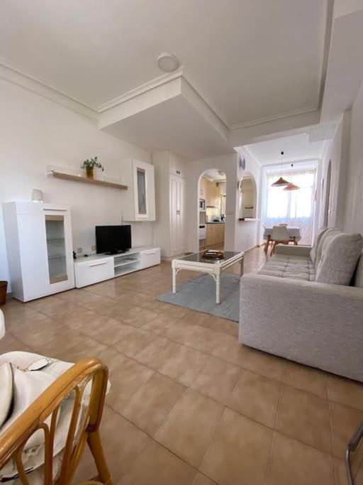 a large living room with a couch and a tv at Punta Prima Gataway in Torrevieja