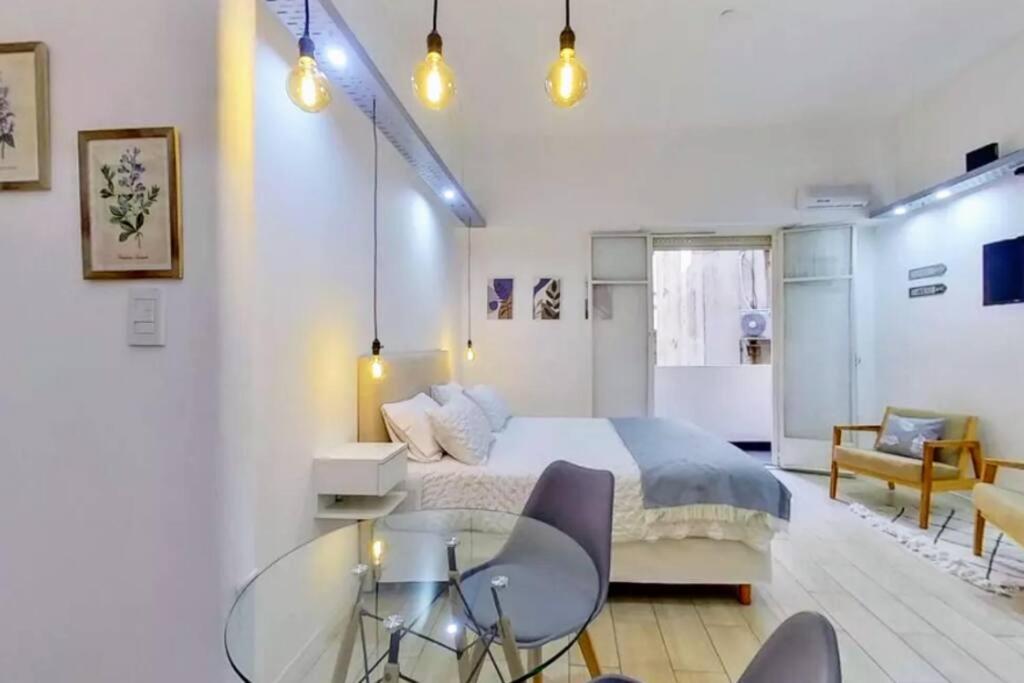 a bedroom with a bed and a glass table and chairs at En el corazón de la ciudad! in Buenos Aires