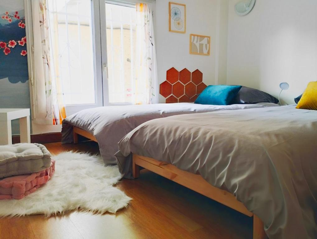 1 Schlafzimmer mit 2 Betten und einem weißen Teppich in der Unterkunft Appartement cosy près de Paris. in Livry-Gargan