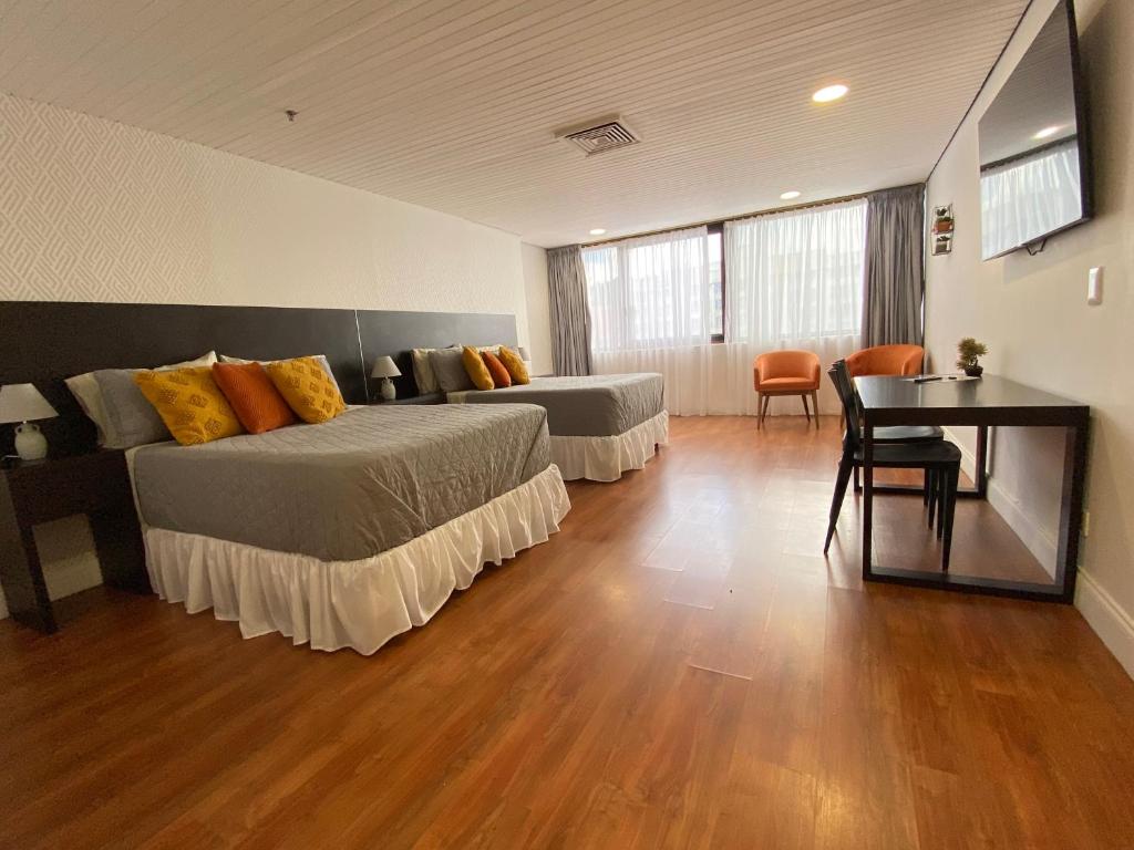 加拉加斯的住宿－Suite. HotelCCT，酒店客房设有两张床和一张桌子。