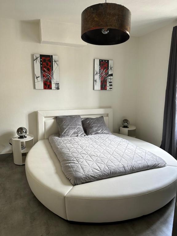 une chambre avec un grand lit blanc dans une pièce dans l'établissement F2 hyper centre ville Lons, à Lons-le-Saunier