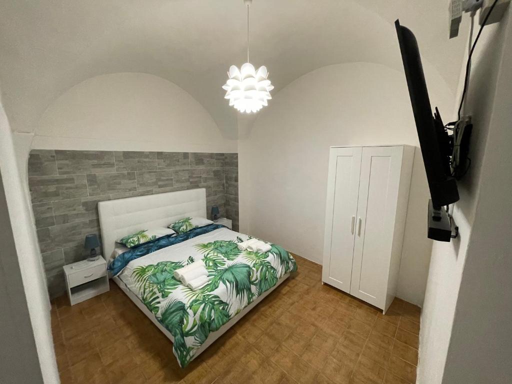 una camera da letto con un letto e un lampadario di Blue Iris Home Sanremo a Sanremo