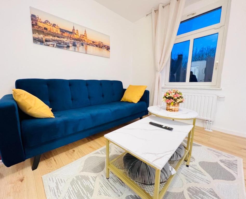 sala de estar con sofá azul y mesa en Twenty Five Apartment, en Heidenau