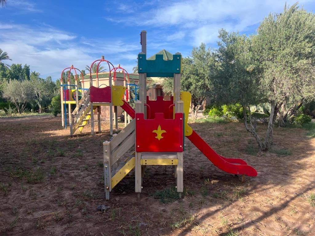 a playground with a slide in a park at Appartement des palmiers avec piscine in Marrakech