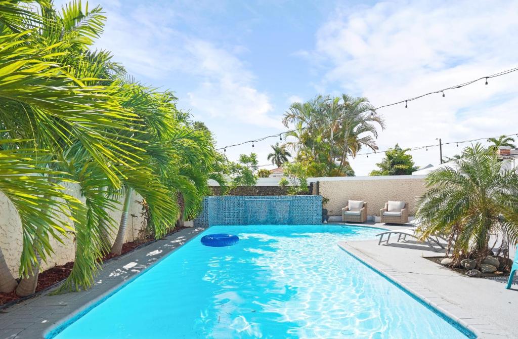a swimming pool in a backyard with palm trees at 4 bedroom family reserve with pool home in Dorado