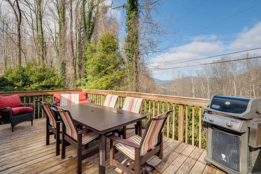 une terrasse en bois avec une table, des chaises et un grill dans l'établissement Peaceful Hendersonville Cabin - Hot Tub and Fire Pit, à Hendersonville