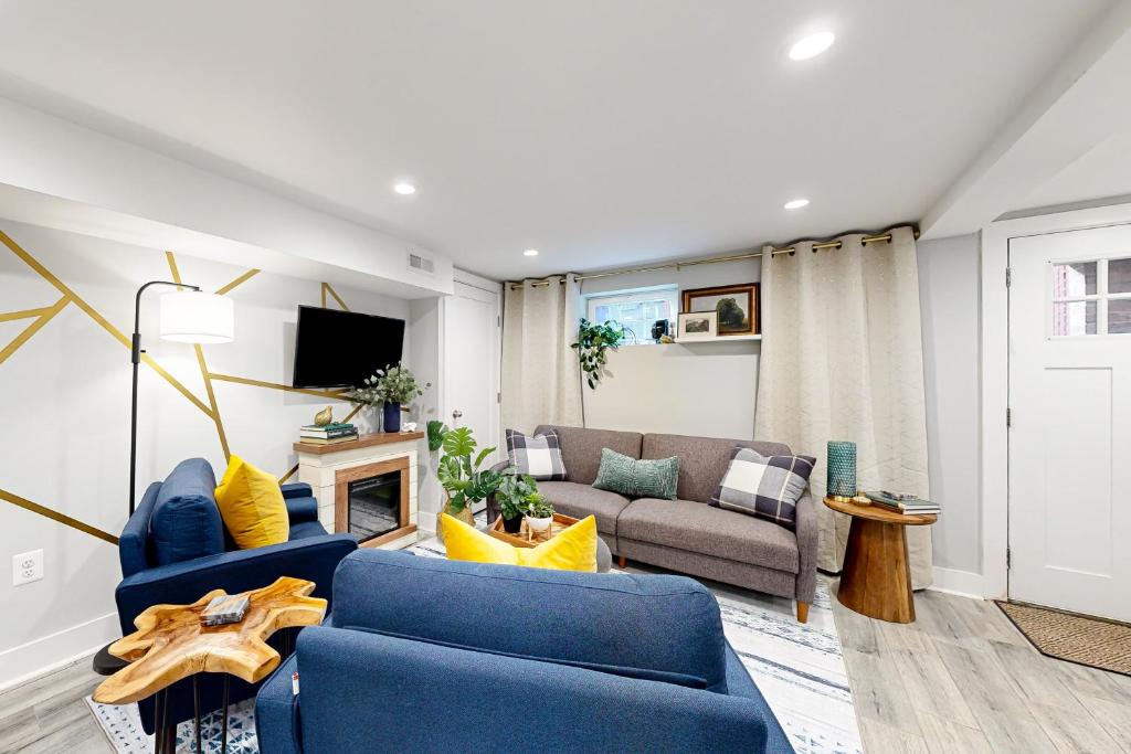 a living room with blue chairs and a couch at Downtown Retreat - Your Urban Oasis in College Park