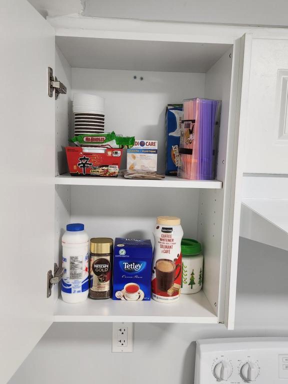 a white cabinet with food items in it at APARTMENT B 2 BEDROOM in Brampton