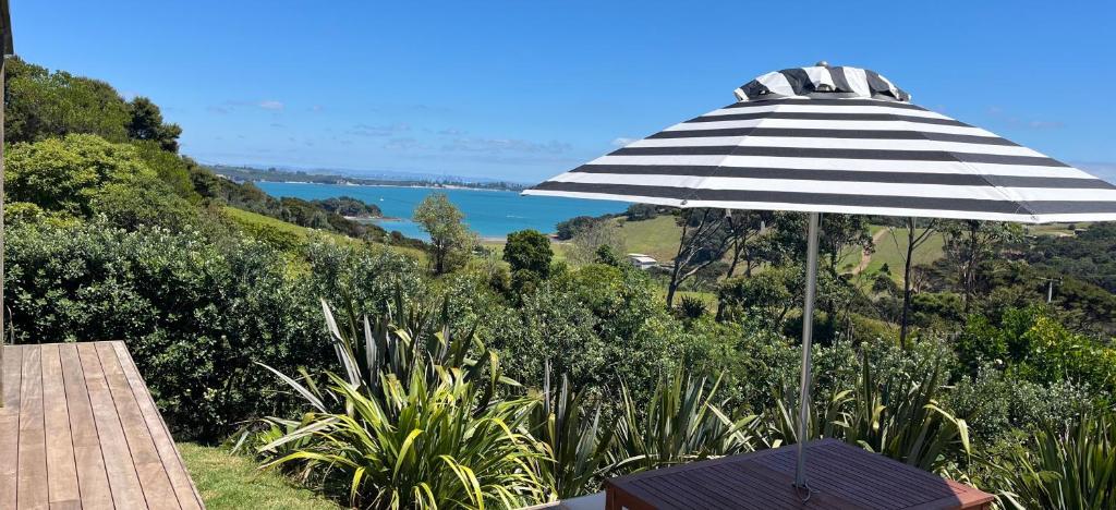 a black and white umbrella sitting on a deck at 125 Church Bay Cabins in Oneroa