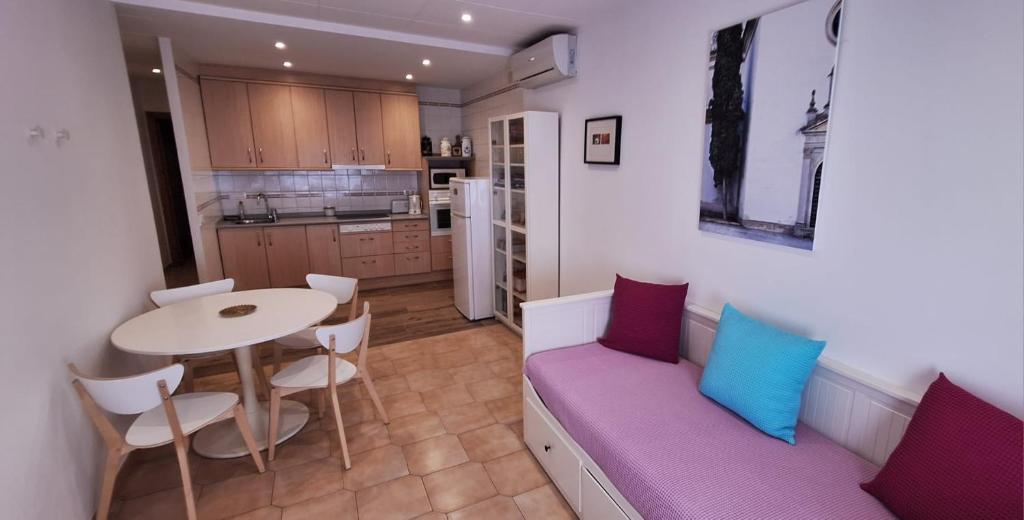 una pequeña cocina con mesa y sofá púrpura en Apartament Perebep de Linyola en Linyola