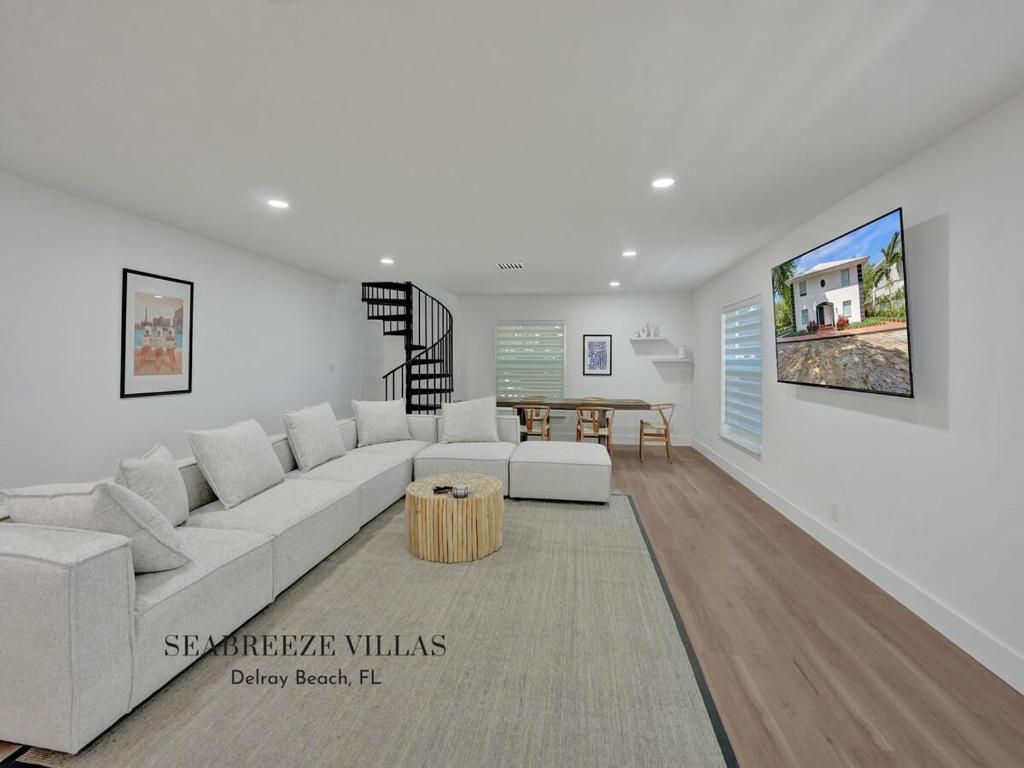 Sala de estar blanca con sofá blanco y mesa en Peaceful Villa Lauren en Delray Beach