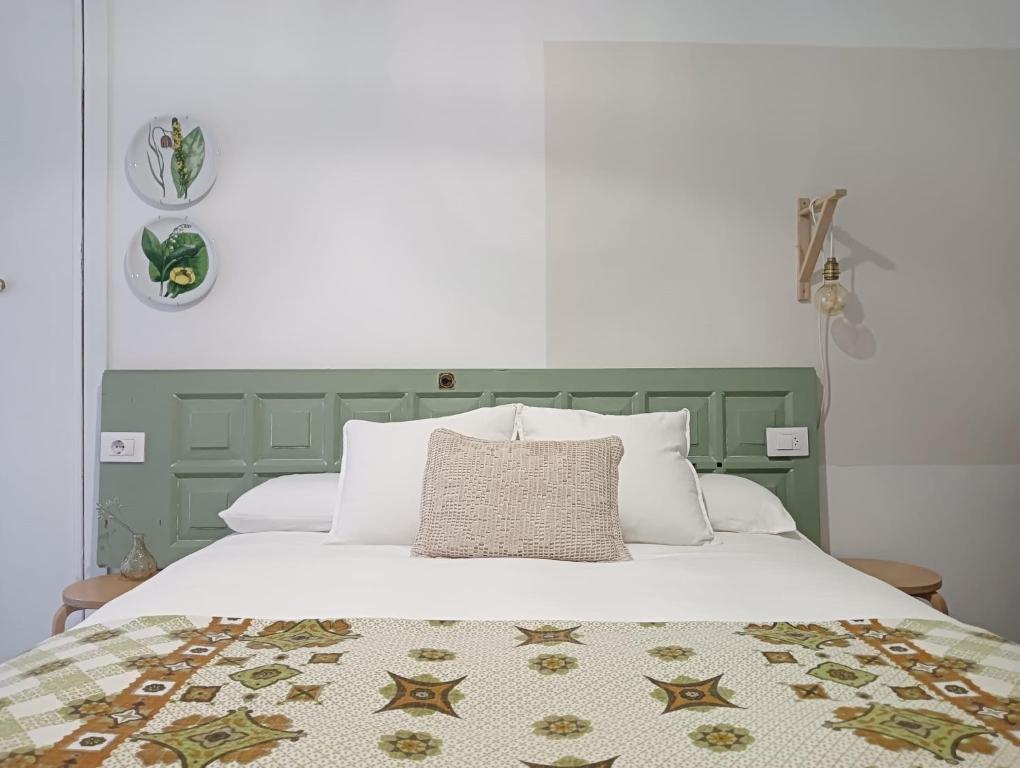 uma cama com uma cabeceira verde com uma almofada em LA MACETA em Vilagarcía de Arousa