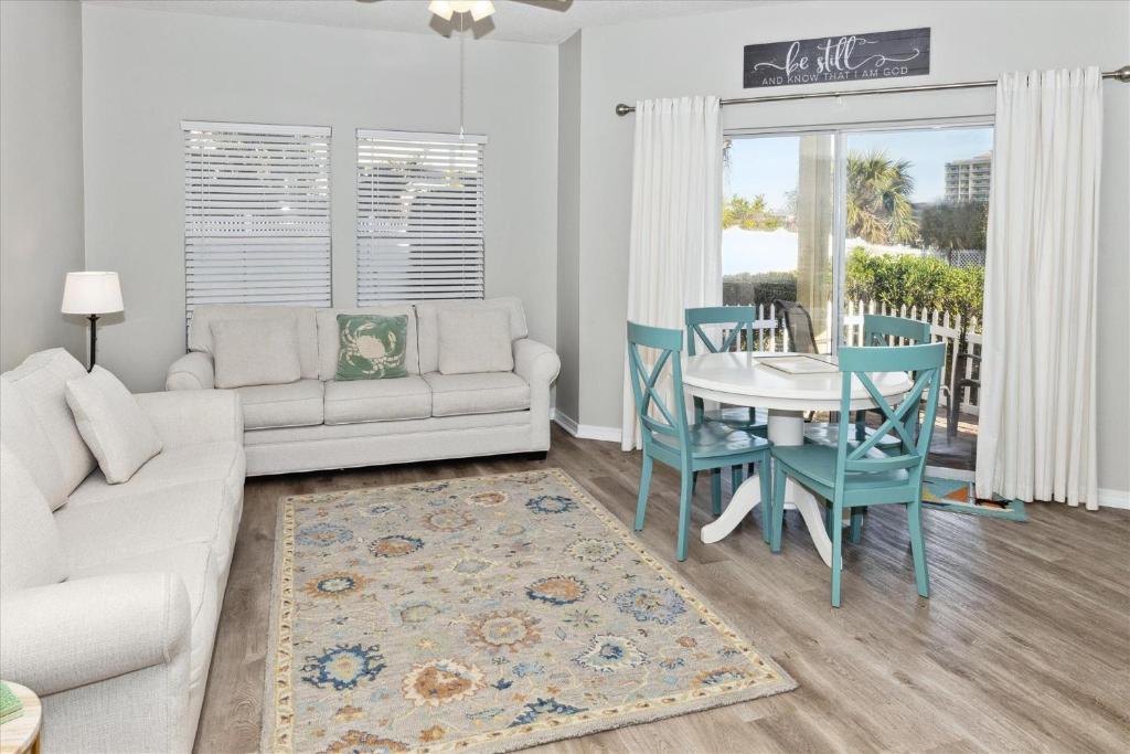 sala de estar con sofá blanco, mesa y sillas en Sandpiper Cove #9124 Condo, en Destin