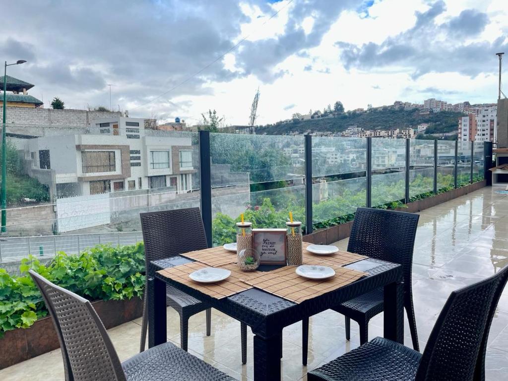 a table and chairs on a balcony with a view at Departamento con jacuzzi, balcón, lavadora y garage in Ambato