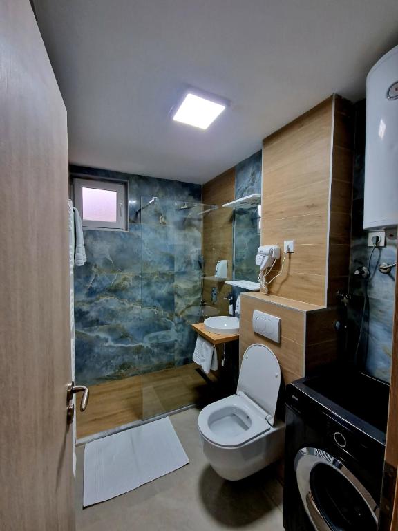 a bathroom with a toilet and a glass shower at Infinity Apartment & Free Wifi & Free Parking in Sarajevo