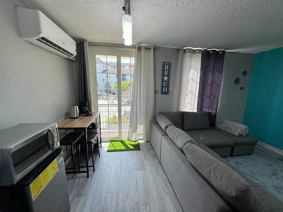 een woonkamer met een bank en een tafel bij Panorama Ochi - Sand Castles Resort B20 in Ocho Rios