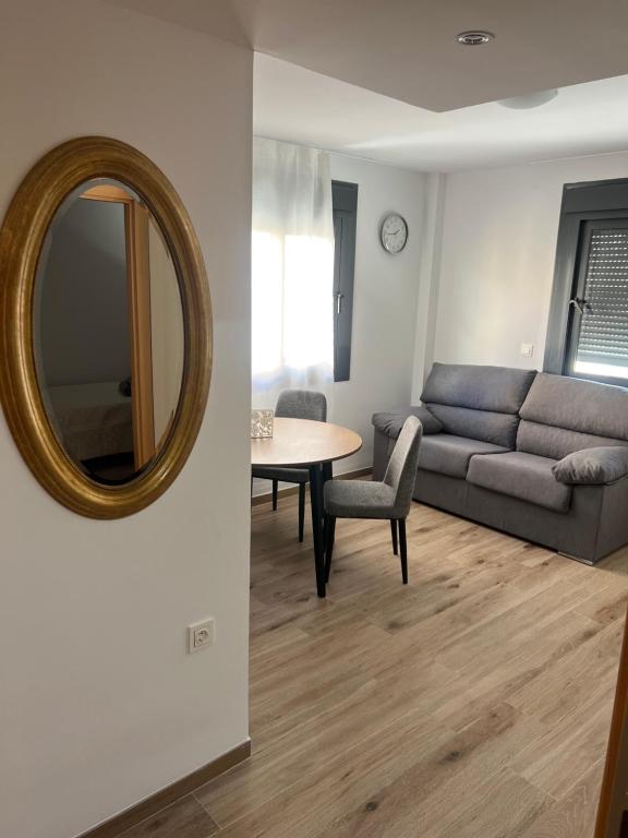 a living room with a couch and a table and a mirror at AB Apartamentos in Melilla