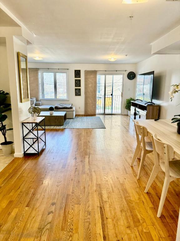a living room with a table and a piano at Stylish Evergreen Apartment By Newark Airport in Newark