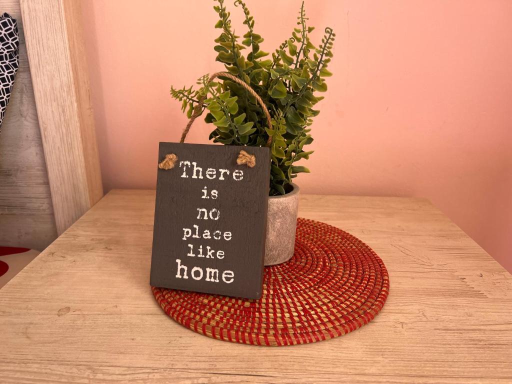 un cartello seduto su un tavolo accanto a una pianta in vaso di Villa spacieuse et agréable a Dakar