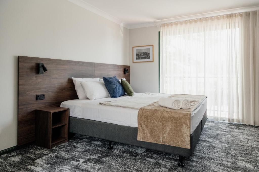 a bedroom with a large bed and a window at Wallaby Hotel in Gold Coast