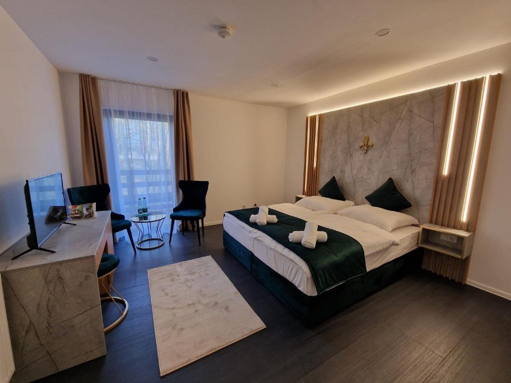 a hotel room with a large bed and a desk at Lilium Resort Hotel & Restaurant in Bad Rodach