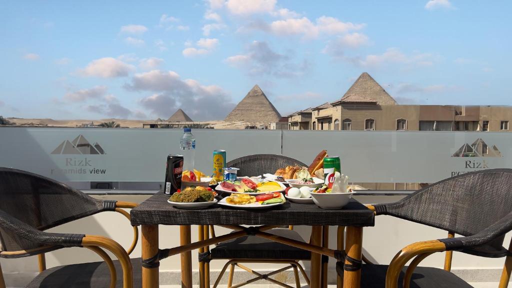 Rizk Pyramids View Hotel في القاهرة: طاولة مع طبق من الطعام على شرفة