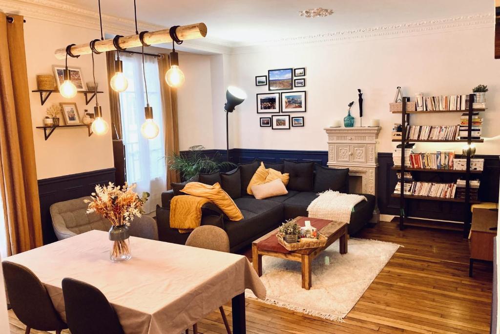 a living room with a couch and a table at Comfortable 76m apartment in Paris