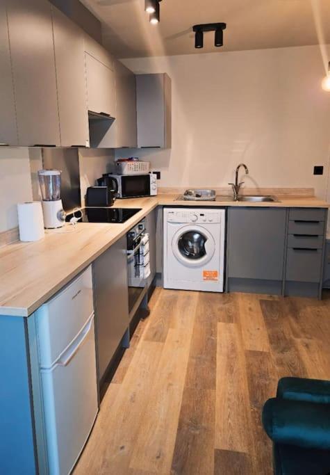 cocina con fogones y lavavajillas en 1-bed flat near Romford station, en Romford