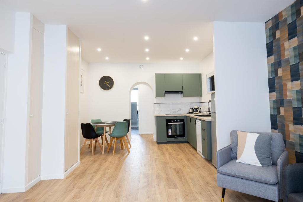 uma cozinha e sala de estar com mesa e cadeiras em Très Bel Appartement Spacieux et Central em Cholet