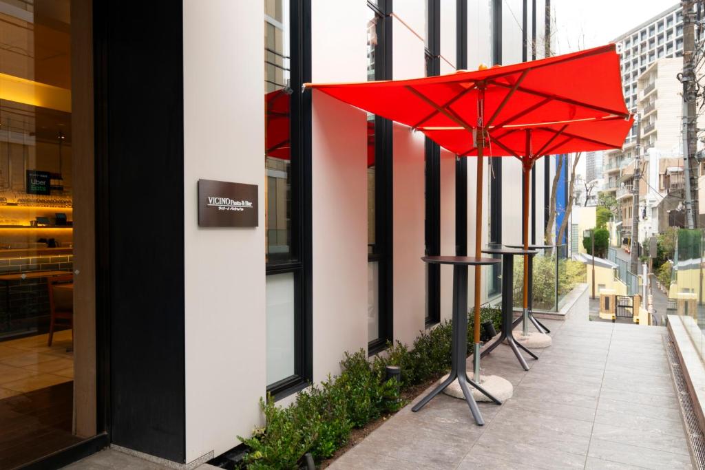 a red umbrella on a sidewalk next to a building at Hotel Mystays Premier Akasaka in Tokyo