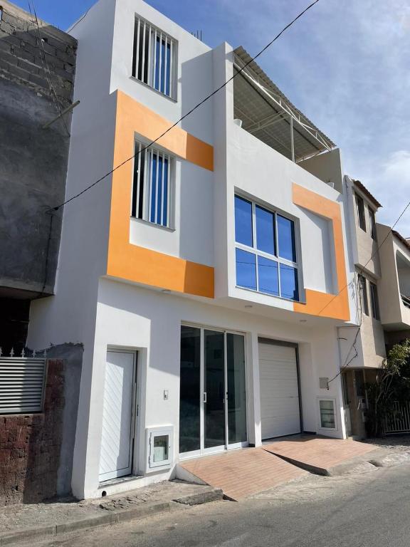 uma casa branca e laranja com uma entrada em madison place em Praia
