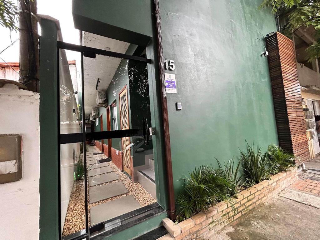 Morada do Sol Suítes في أرايال دو كابو: مدخل لمبنى فيه باب أخضر