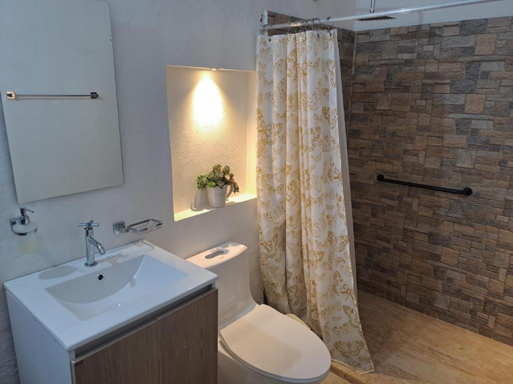 萊瓦鎮的住宿－Apartahotel Sacrosanta Trinidad，浴室配有卫生间、盥洗盆和淋浴。