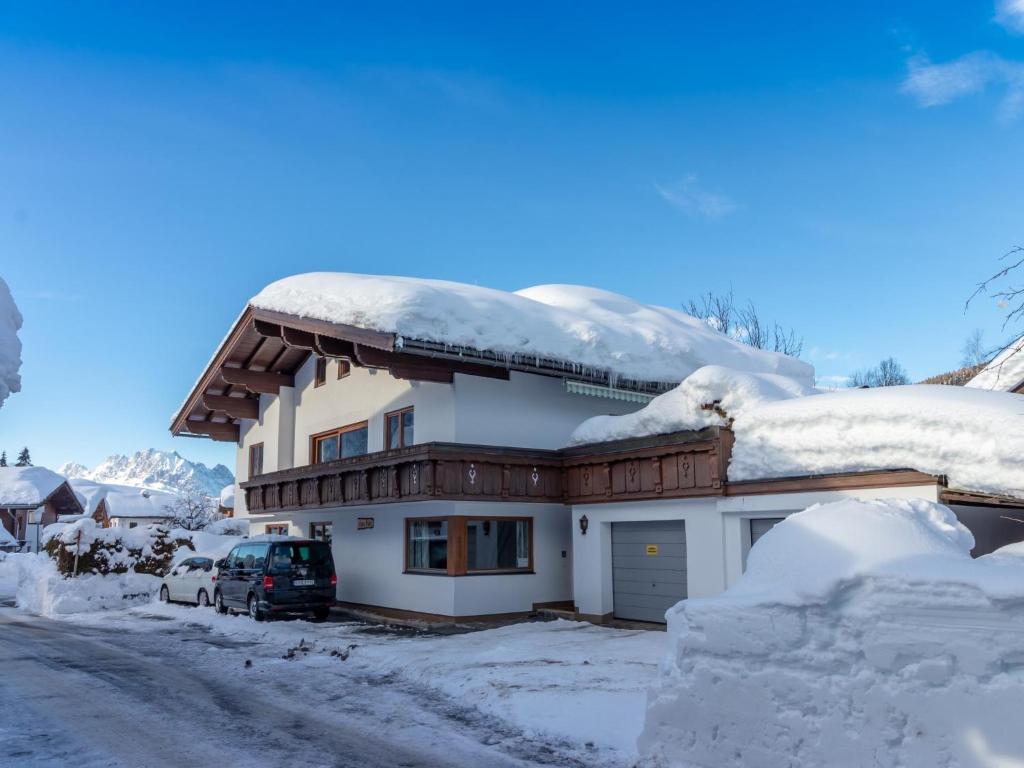 una casa cubierta de nieve con un coche aparcado delante en Wald TOP 2, en Fieberbrunn