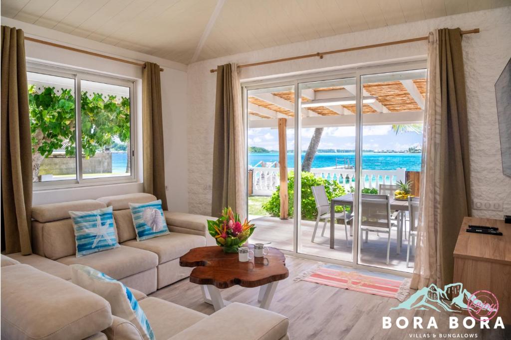 a living room with a couch and a table at Matira Beach House in Bora Bora