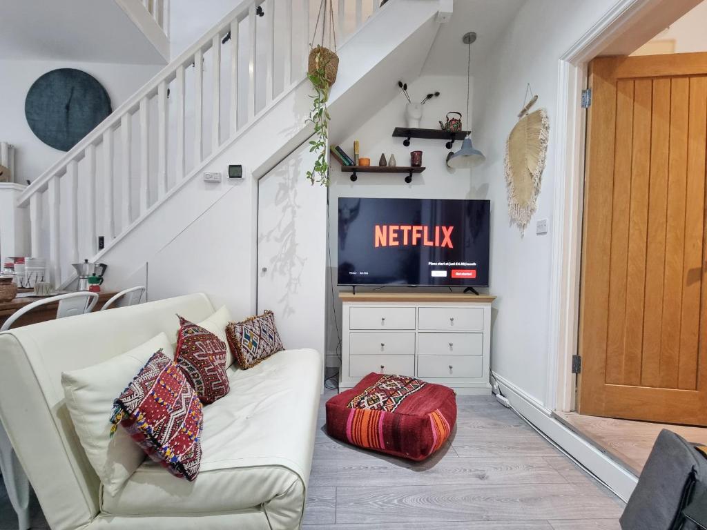uma sala de estar com um sofá branco e uma televisão em 4bed/3bath 8min to London Bridge em Londres