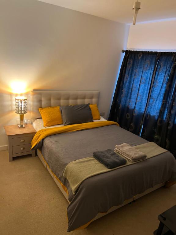 Central Town Apartment في Kent: غرفة نوم بسرير كبير مع ستائر زرقاء