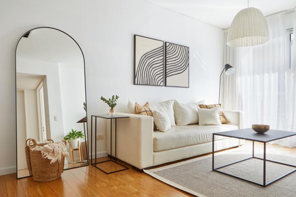 uma sala de estar com um sofá branco e uma mesa em Quartier Polo by RentinBA em Buenos Aires