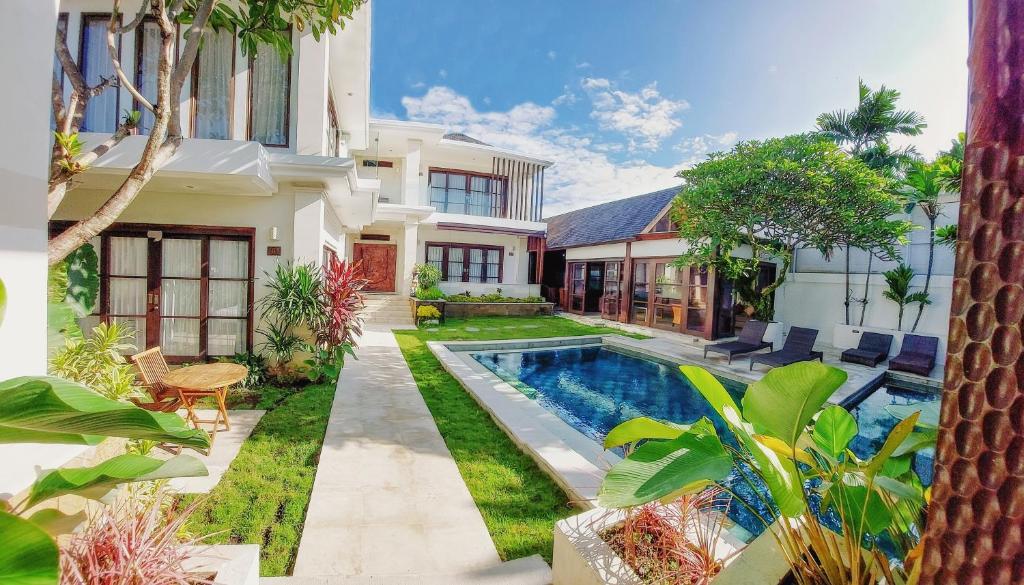 an exterior view of a house with a swimming pool at Villa Harmony - Residence in Seminyak