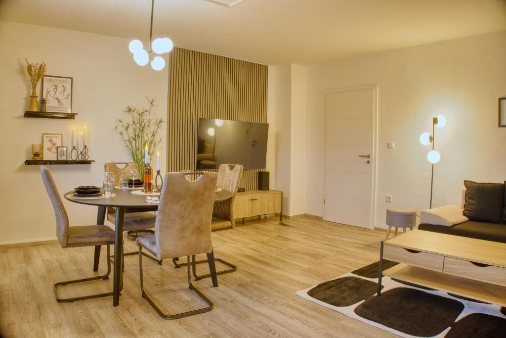 - un salon avec une table, des chaises et un canapé dans l'établissement No.4 by 21 Apartments, à Kaarst