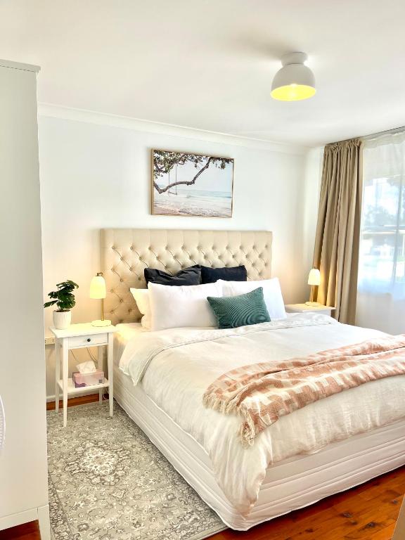 Un dormitorio blanco con una cama grande y una ventana en Sunshine Retreat Modern 3BR Haven, en St Marys