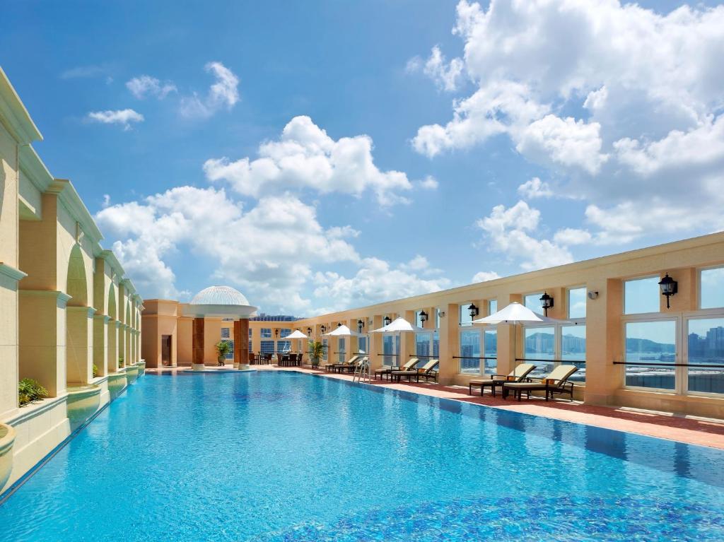 een zwembad in een hotel met een blauwe lucht bij The Royal Garden in Hong Kong