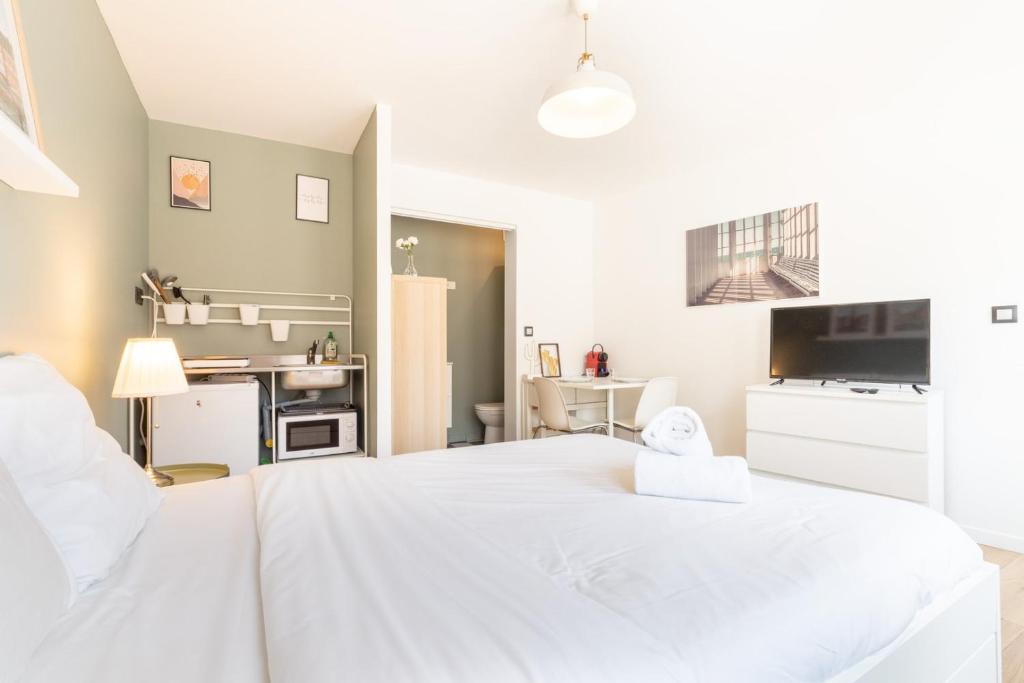 une chambre avec un grand lit blanc dans une pièce dans l'établissement Vieux Lille : Equipped studio, à Lille